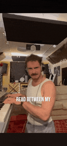 a man playing a piano with the words read between my on the bottom right