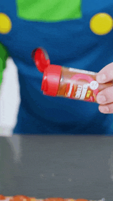 a person is pouring sauce on a pizza with a bottle that says ' mr. pepper ' on it