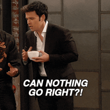 a man in a suit is holding a white bowl and says can nothing go right