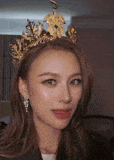 a close up of a woman wearing a crown and earrings