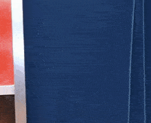a person is peeking out from behind a blue curtain