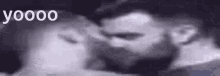 a man and a woman are kissing in a black and white photo with the words yoooo written on the bottom .