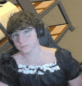 a man wearing glasses and headphones looks at the camera