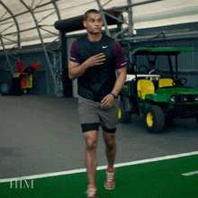 a man wearing a nike vest and shorts is running