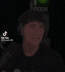 a man wearing headphones is making a funny face in front of a microphone .