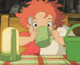 a little girl with red hair drinking from a green cup