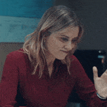 a woman in a red shirt is sitting at a desk with the words back to the in white letters