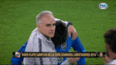 a fox sports screen shows a man hugging another man on a soccer field