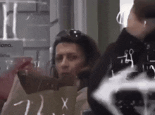 a woman is holding a bag that says 7 2 x on it
