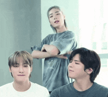 a group of young men are posing for a picture and one of them is wearing a gray shirt