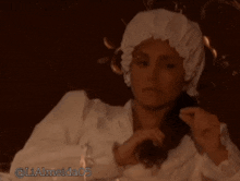 a woman wearing a white hat is laying on a bed with the name lialmeida05 on the bottom right