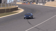a blue car is driving down a road with a white line on it