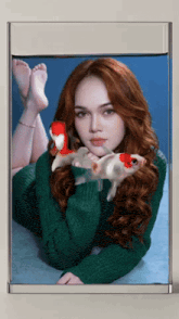 a picture of a woman in a green sweater with two fish in her hands