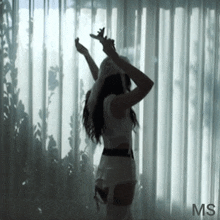 a silhouette of a woman standing in front of a window with the letters ms on the bottom