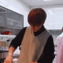 a man in an apron is standing in a kitchen preparing food