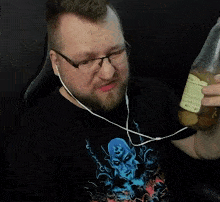 a man wearing glasses and earbuds is holding a bottle