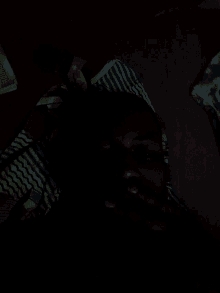 a person in a striped shirt is laying on a bed