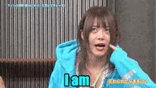 a woman in a blue hoodie says " i am "