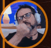 a man with glasses and a beard is wearing headphones .