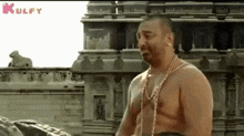a man without a shirt is standing in front of a building .