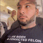a man wearing a shirt that says joe biden convicted felon on it