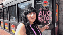 a woman stands in front of a building that says laugh factory diego