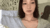 a woman is taking a selfie in front of a mirror while wearing a blue shirt .