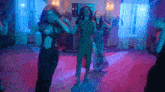 a group of women are dancing in a room with purple lighting