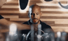 a man is sitting at a table with his eyes closed while a bartender pours a drink into his glass .