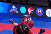 a man in a black shirt with kat on the back is fighting another man