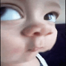 a close up of a baby 's face making a funny face and looking at the camera .