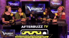 four women are sitting at a table with microphones in front of a screen that says voltron on it