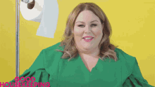 a woman in a green shirt stands in front of a roll of toilet paper with the words good housekeeping written on the bottom