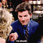 a man in a suit and tie is talking to a woman and says " i 'm drunk "