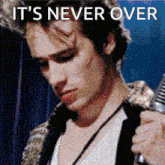 a man is singing into a microphone with the words it 's never over written above him