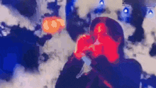 a man is singing into a microphone in front of a crowd of people .