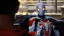 a man in a red and white spiderman costume is standing next to another man
