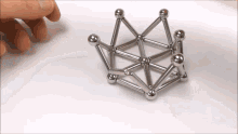 a person is playing with a magnetic toy that looks like a crown