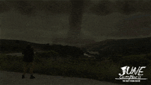 a poster for june campbell shows a man looking at a storm