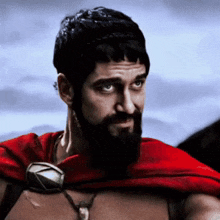 a man with a beard wearing a red cape