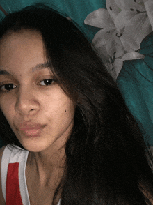 a young woman with long dark hair is looking at the camera