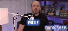 a man sitting in front of a microphone with the words dark web on the bottom