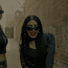 a woman wearing sunglasses is laughing while walking down a street