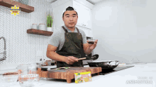 a man in an apron is cooking in a kitchen with a sign that says panasonic pinoy