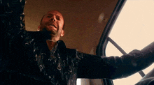 a man in a black shirt with hearts on it is looking up