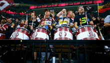 a group of people sitting in a stadium with drums that say sparta