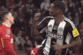 a soccer player wearing a black and white striped shirt with the word kisela on it