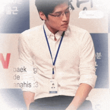 a man wearing glasses and a lanyard that says baek de anahis