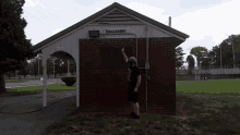 a man stands in front of a building that says restrooms on it