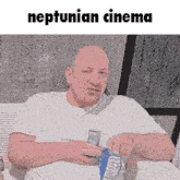a man in a white shirt is sitting on a couch with the words neptunian cinema above him